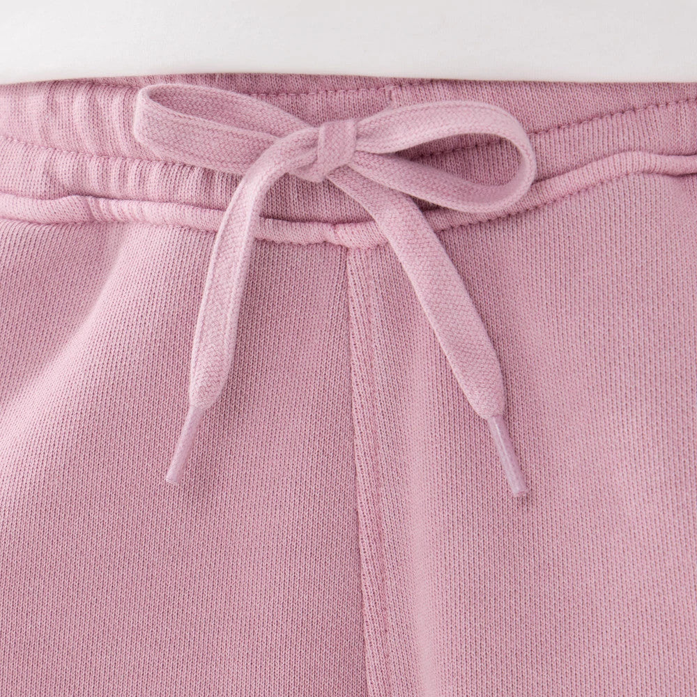 New Era Originators Pink Oversized Shorts, front view showing the drawstring detail tied in a bow at the waistband with gathered fabric extending below, highlighting the soft pink colour and relaxed fit.
