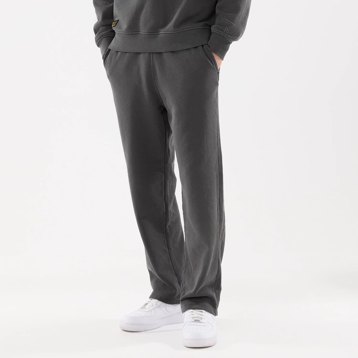 The model is wearing this New Era Originators Straight Leg Joggers in black. 1