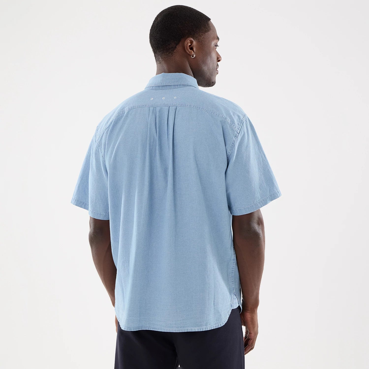 The model is wearing this New Era Originators Chambray Short Sleeve Shirt in bright blue. 2