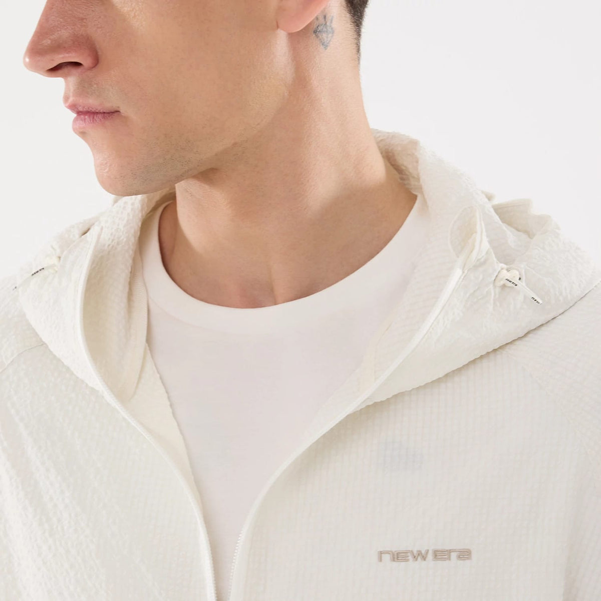 The model is wearing this New Era Black Label Jacket in open white. 4