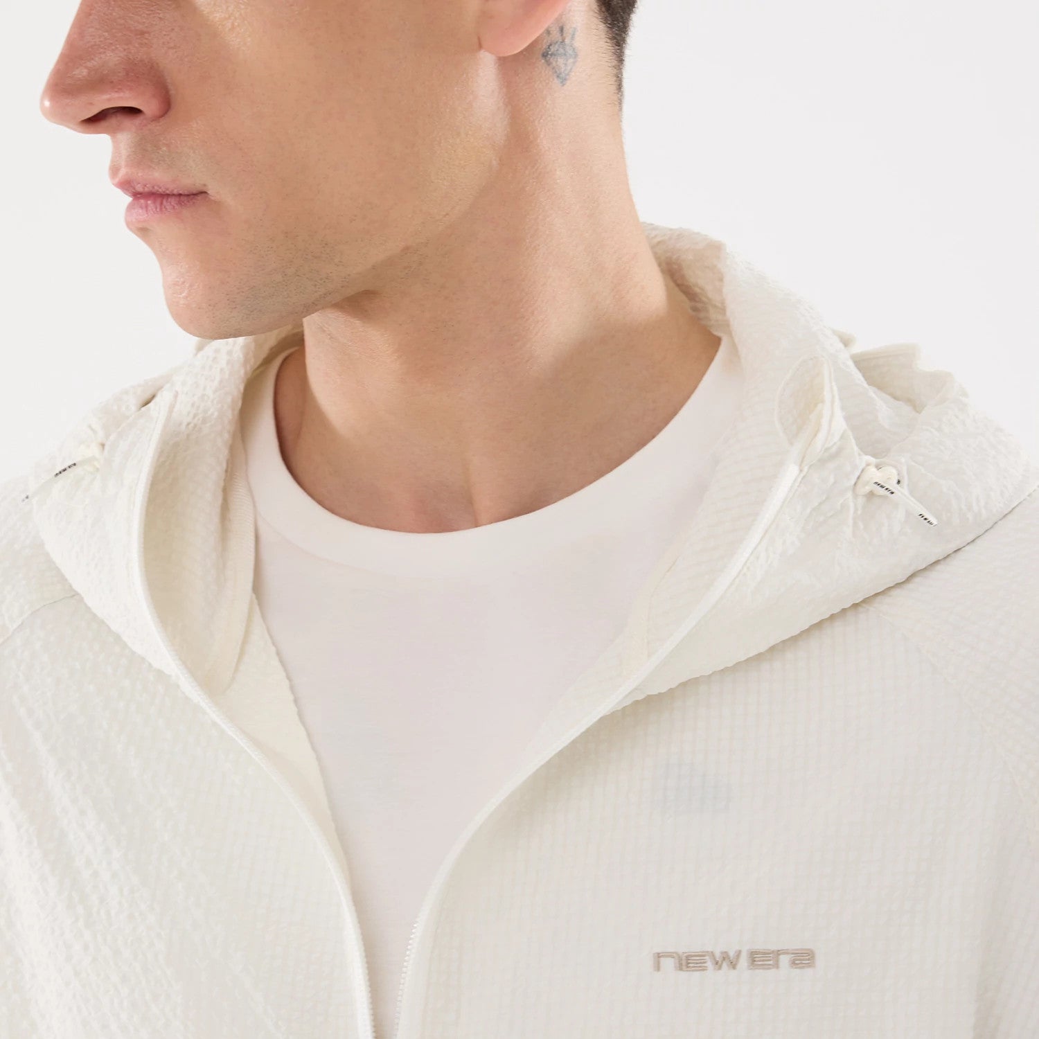The model is wearing this New Era Black Label Jacket in open white. 4