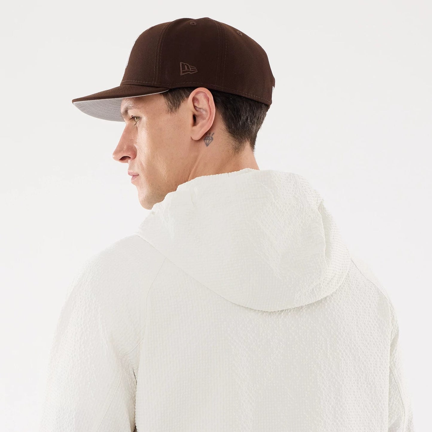 The model is wearing this New Era Black Label Jacket in open white. 7
