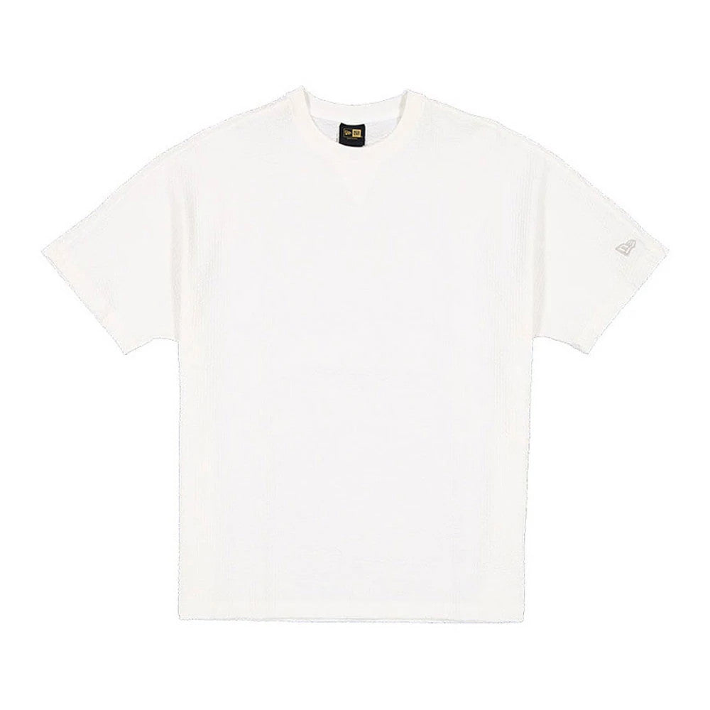 New Era Black Label Seersucker Cream T-Shirt, front view showing the plain cream short-sleeve design with a round neck, featuring a debossed New Era logo on the left sleeve near the hem.