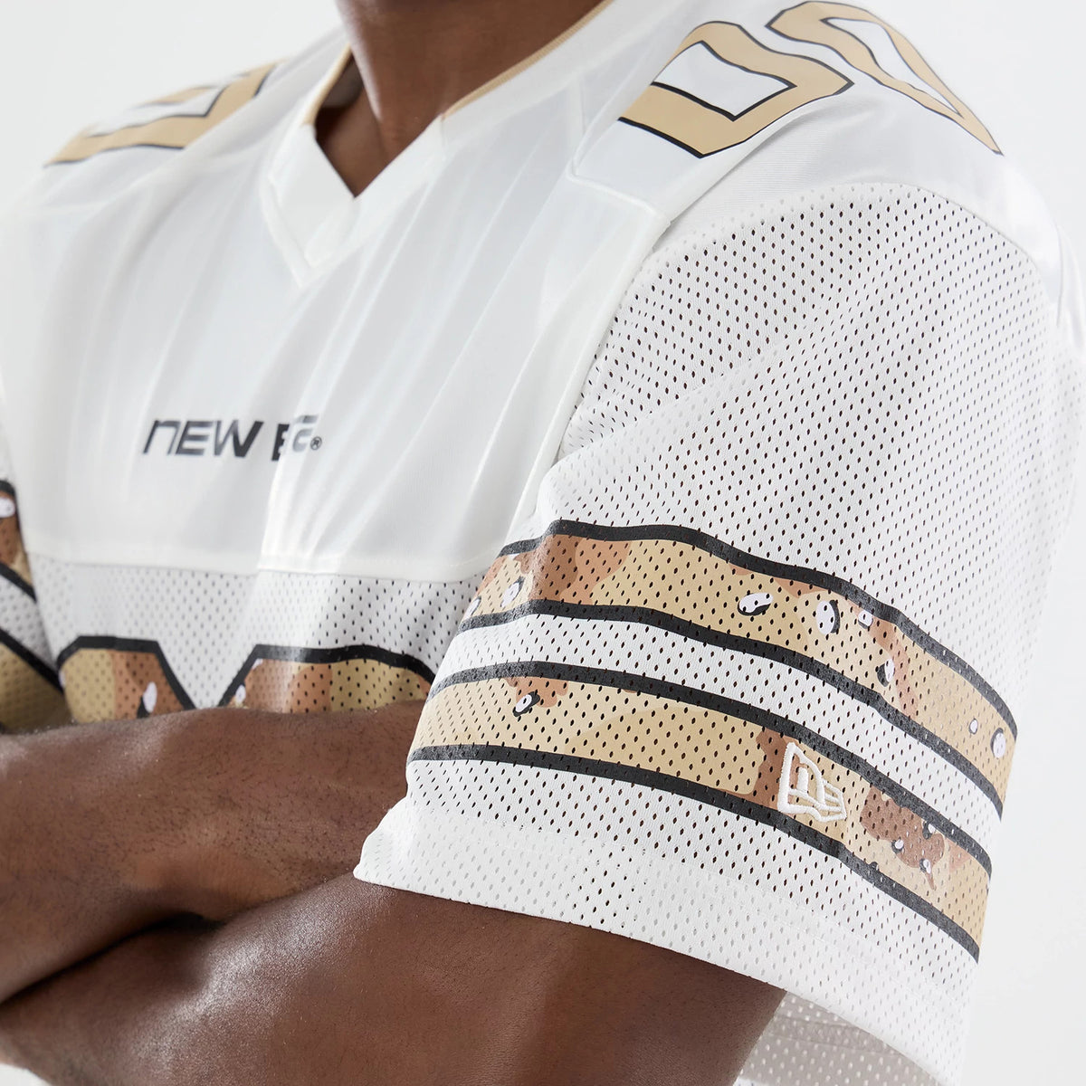 New Era 1920 White Mesh Jersey, side view on a model showing the white perforated mesh fabric with gold and black striped detailing on the sleeves, and the New Era flag logo near the cuff.