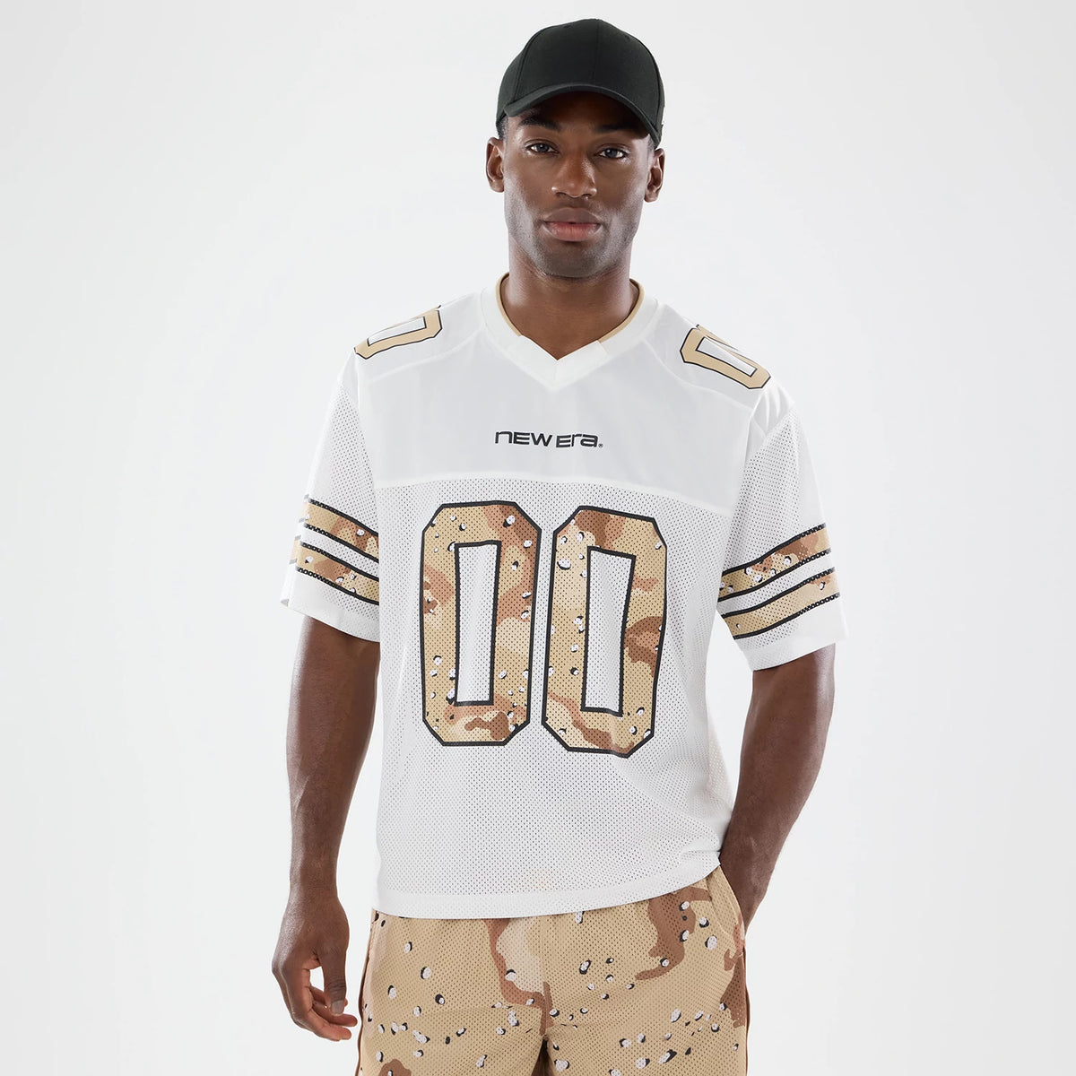 New Era 1920 White Mesh Jersey, front view on a model wearing camouflage shorts, featuring large gold and brown camo numbers on the white mesh fabric with a New Era wordmark stitched on the chest.