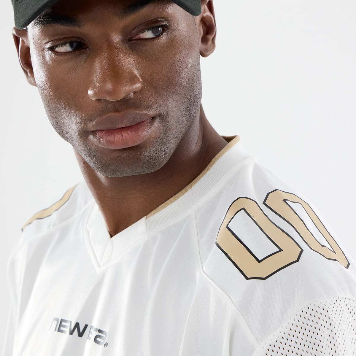 New Era 1920 White Mesh Jersey, three-quarter view on a model with a black cap, featuring gold "00" graphics on the shoulder and New Era wordmark across the chest, highlighting perforated mesh detailing on the sleeve.