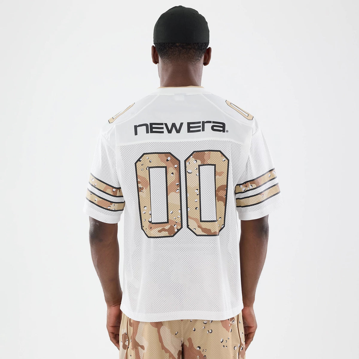 New Era 1920 White Mesh Jersey, back view on a model wearing camouflage shorts and a black cap, featuring black New Era lettering across the shoulders and oversized camo-styled 00 numerals on the back.