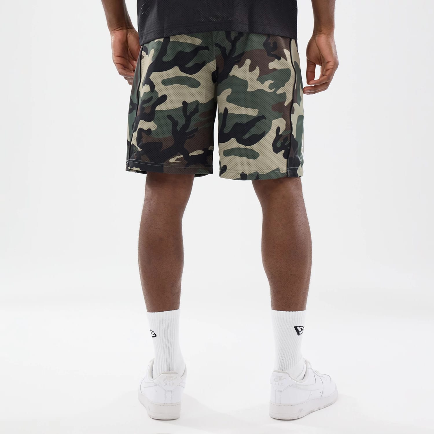 The model is wearing this New Era Bermuda Oversized Shorts in 6 Day Camo. 2
