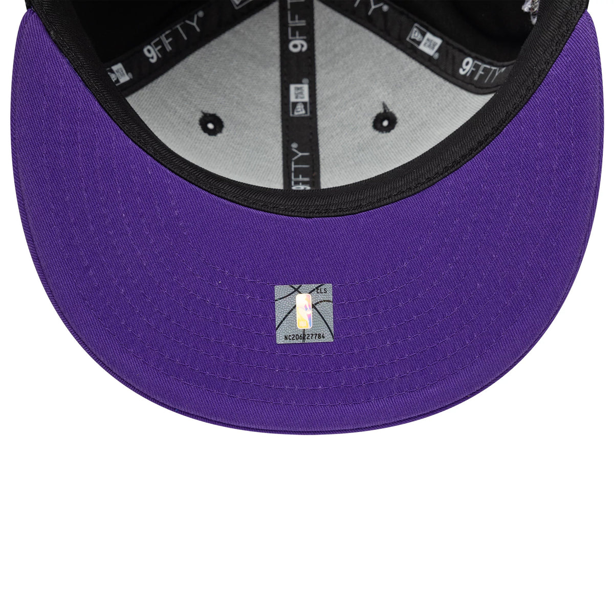 Toronto Raptors NBA Hardwood Classic Black New Era 9FIFTY Snapback Adjustable Cap, inside view showing the black sweatband with 9FIFTY taping and a purple undervisor featuring the NBA logo sticker at the centre.