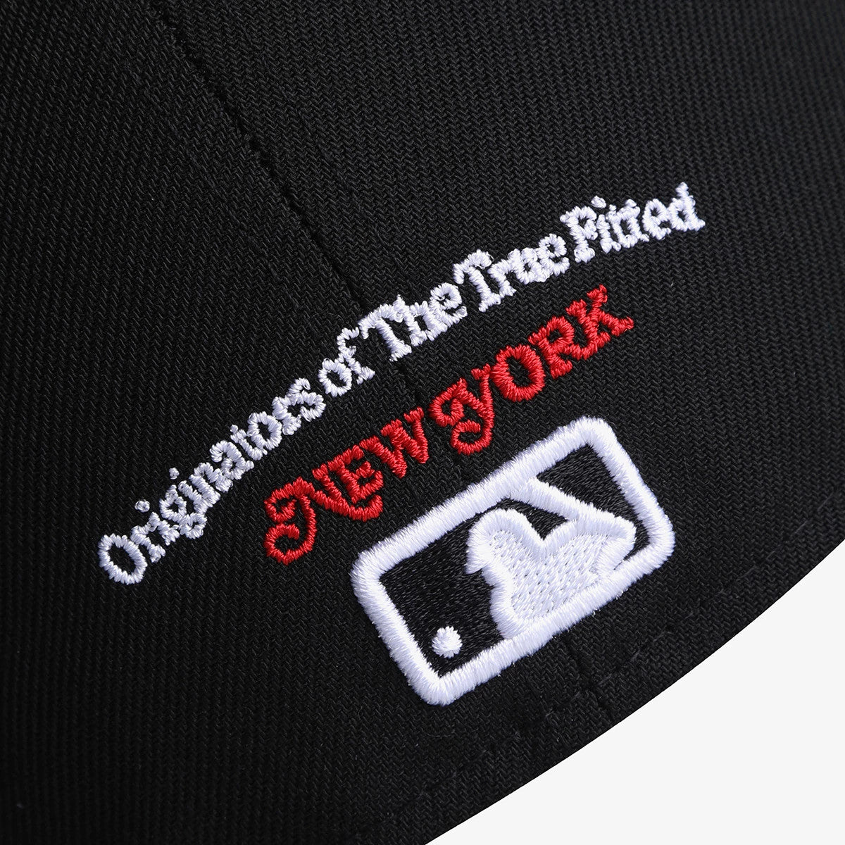 New York Yankees MLB 59FIFTY Day Black New Era 59FIFTY Fitted Cap, rear view showing the white embroidered MLB Batterman logo at the centre back, with "New York" in red and "Originators Of The True Fitted" in white above it.