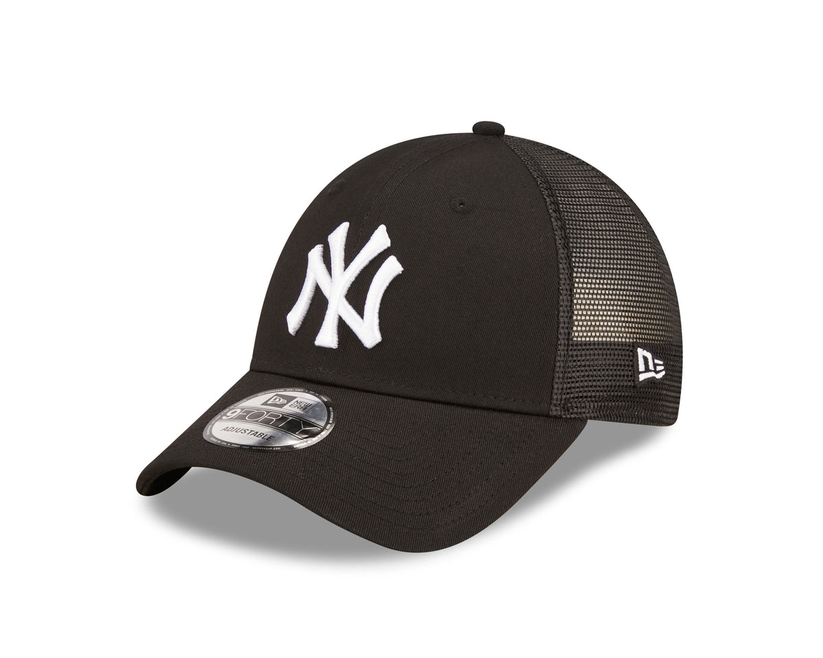New York Yankees Home Field Black New Era 9FORTY A-Frame Trucker Cap, three-quarter view showing the raised white NY logo on the front panel, black mesh side panels, New Era flag logo on the left side, and 9FORTY size sticker on the curved visor.