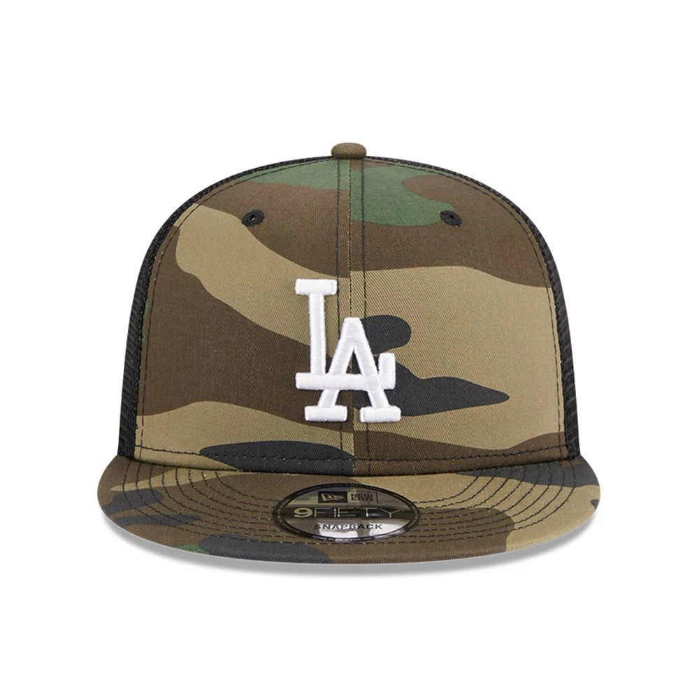LA Dodgers MLB Evergreen Camo New Era 9FIFTY Trucker Adjustable Cap, front view showing raised white LA logo embroidered on camo print, with a black mesh back and 9FIFTY size sticker on the camo visor.