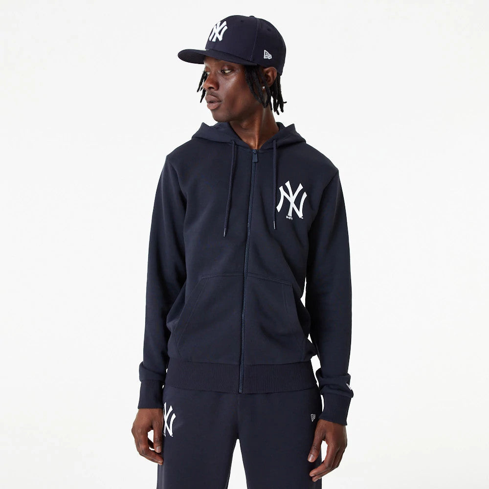 New York Yankees MLB Essential Navy Full Zip Hoodie, on-model view showing the navy hoodie with the white embroidered Yankees logo on the left chest, matching navy drawstrings, and a full-length zip closure down the front.