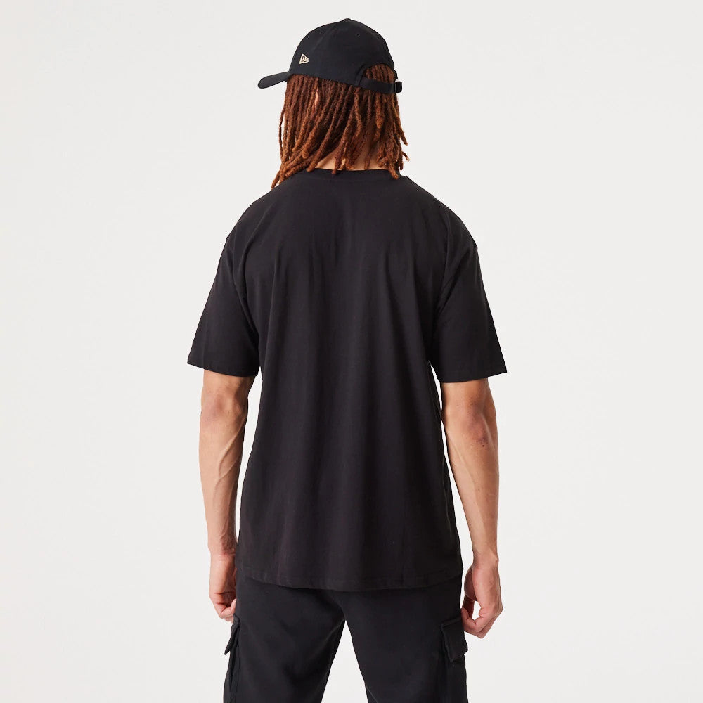 New York Yankees MLB Essential Black Oversized T-Shirt, rear view showing the plain black back of the T-shirt worn by a person, with a black cap featuring an embossed New Era logo on the side of the cap.