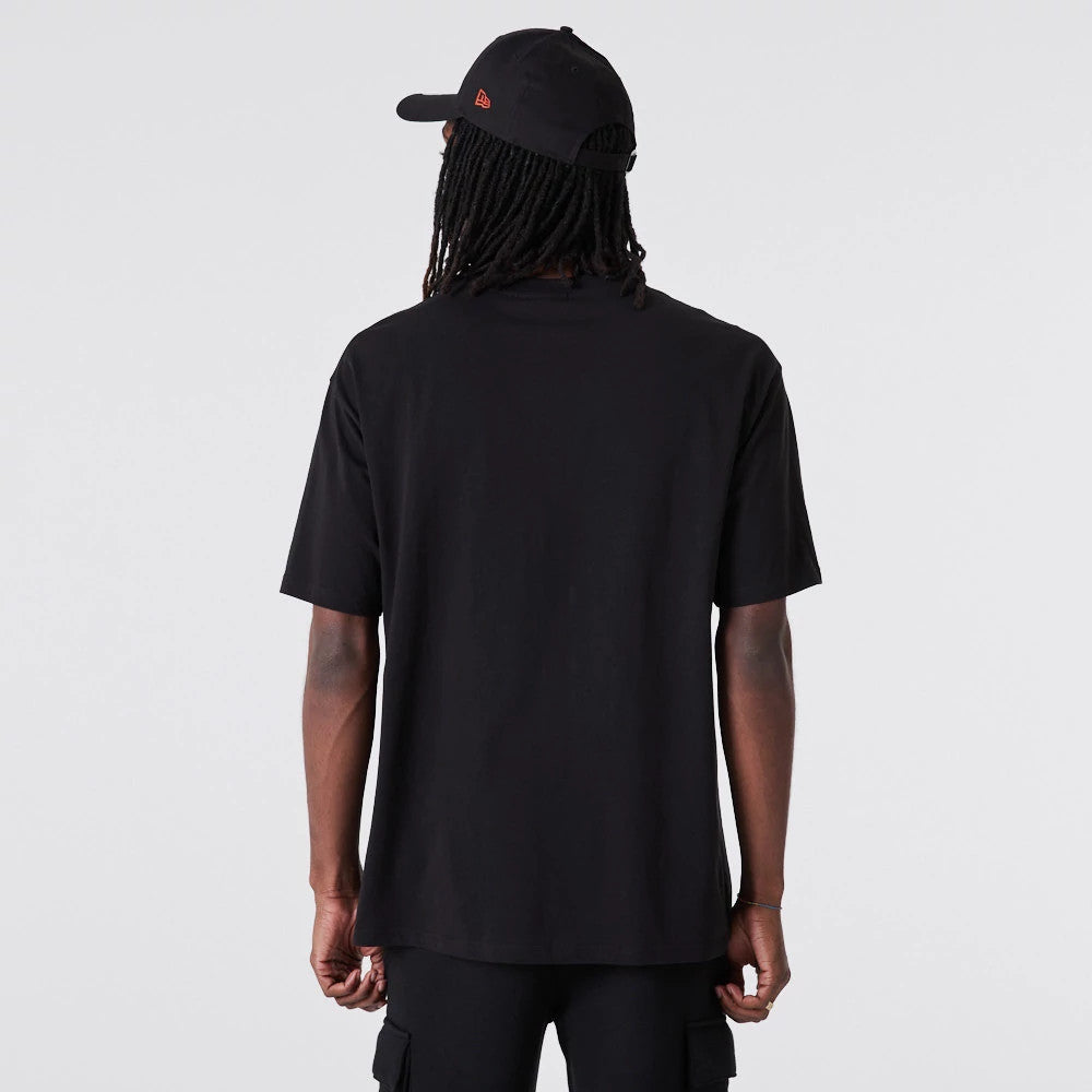 Chicago White Sox MLB Essential Black Oversized T-Shirt, rear view showing the plain black back extending over the shoulders and down the arms, paired with a black cap featuring a raised red New Era logo on the side.