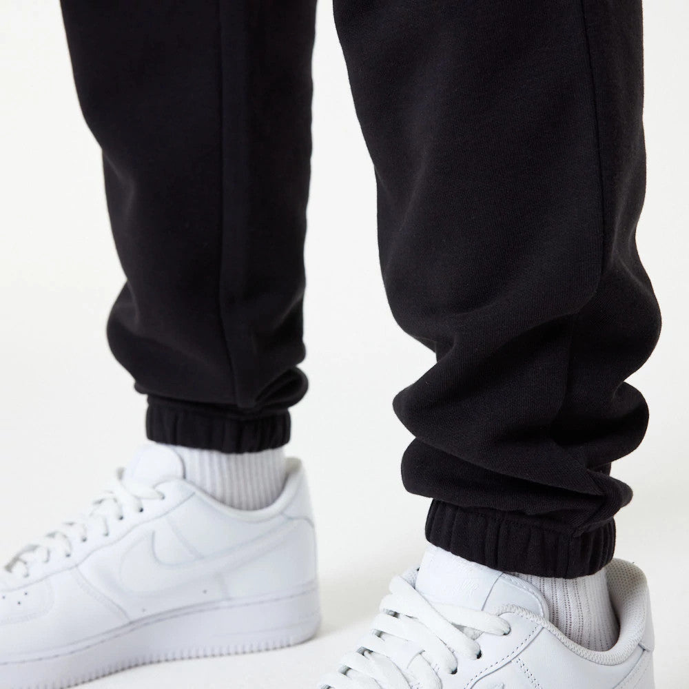New Era New York Yankees MLB Essential Black Joggers, close-up showing elasticated cuffs gathered at the ankles, paired with white sneakers and socks for a casual style.