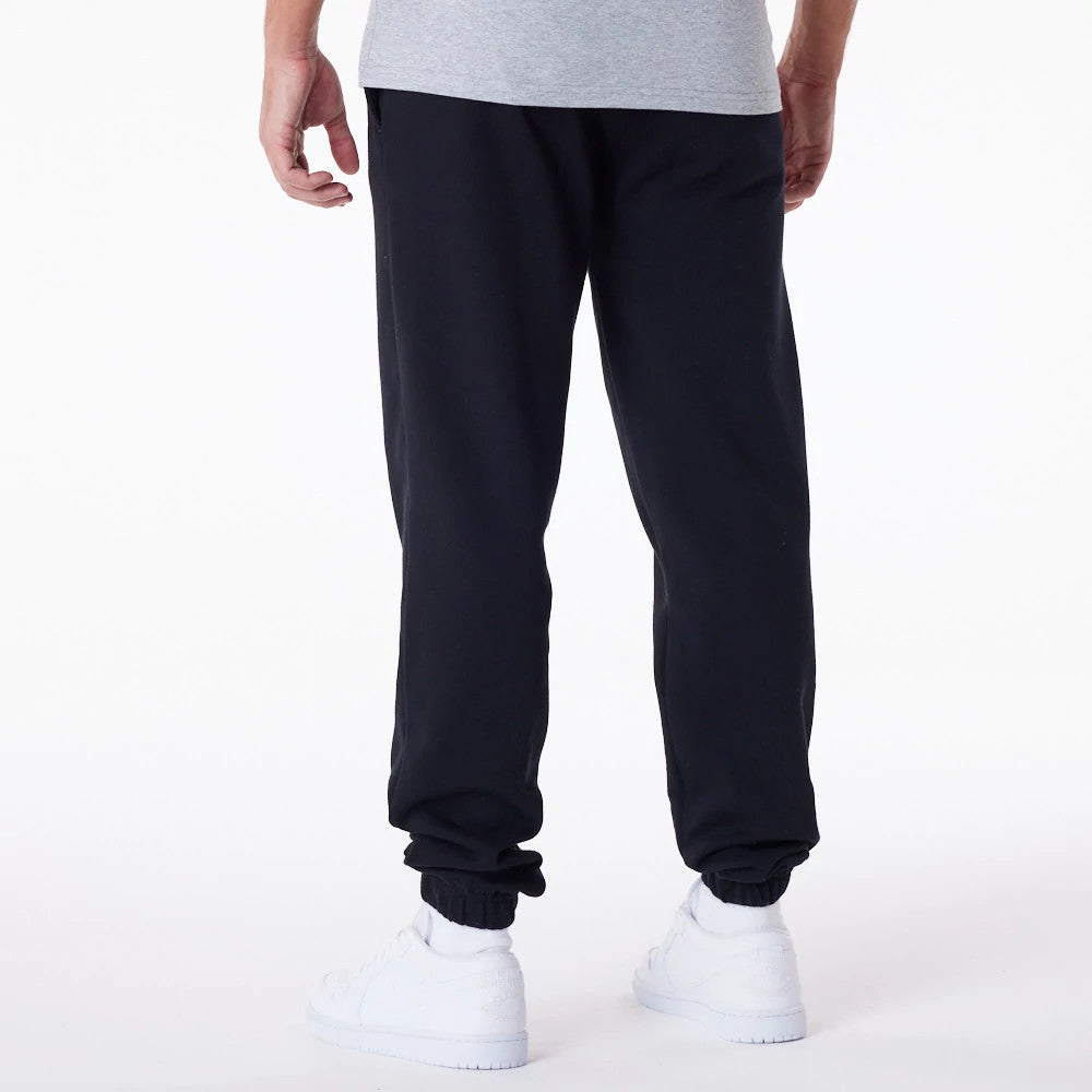 Chicago Bulls NBA Essential Black Joggers, rear view on a model styled with a grey T-shirt, featuring an elasticated waistband and cuffs, providing a relaxed fit with subtle seam detailing down the legs.