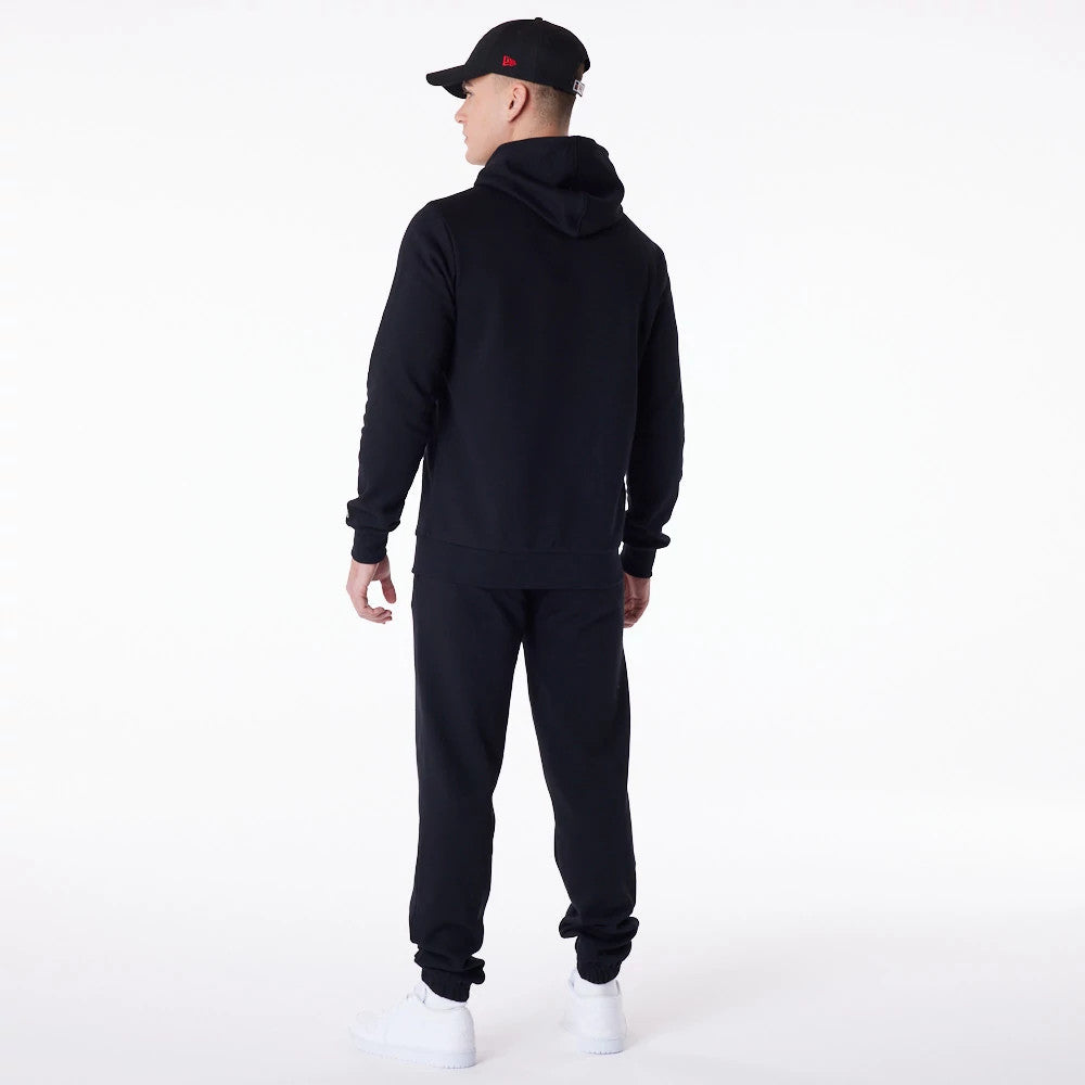 Chicago Bulls NBA Essential Black Full Zip Hoodie, on-model view showing the back of the black hoodie with the hood lying flat, paired with matching black trousers and white trainers, worn with a black cap featuring a red debossed logo.