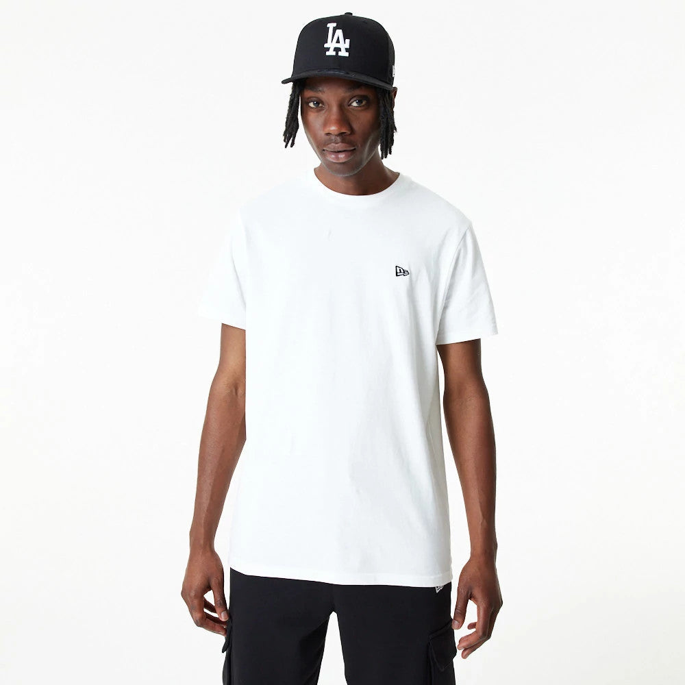 New Era Essential White T-Shirt, front view showing a plain white design with a small raised New Era logo on the left chest, worn by a person with a black New Era cap featuring a raised "LA" logo.
