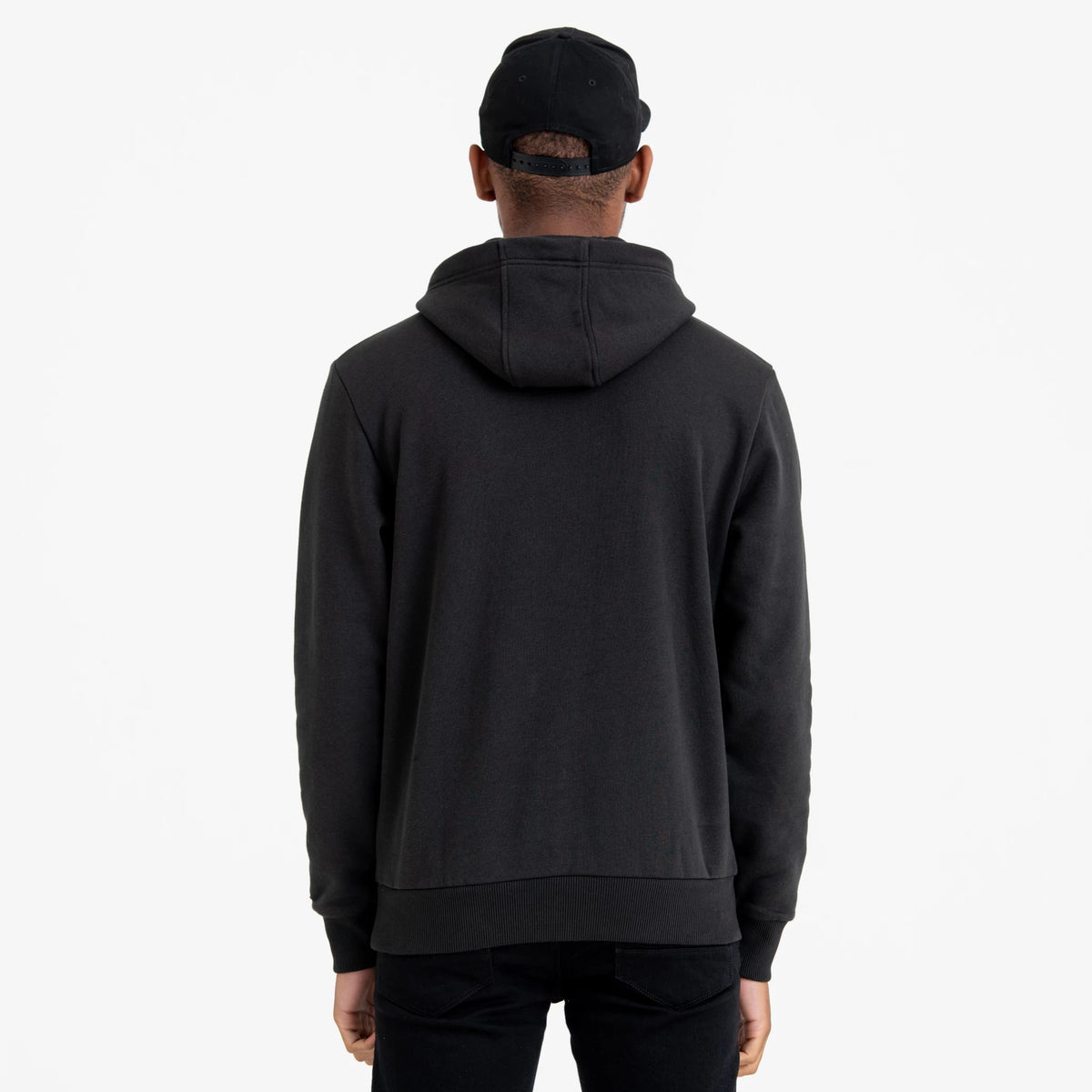 New York Yankees MLB Regular Black Pullover Hoodie, rear view showing the plain black hoodie from the back with a relaxed fit, attached hood, and long sleeves, worn by a person also wearing a black cap.