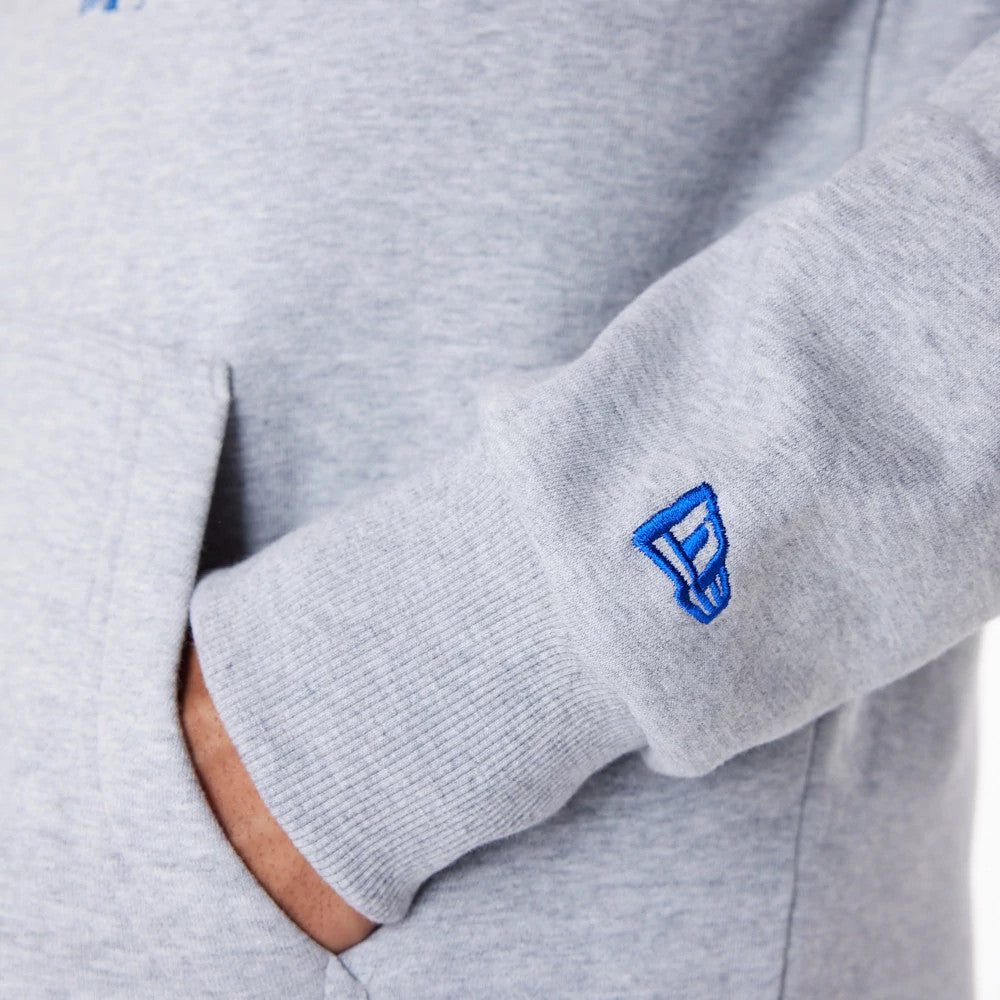 LA Dodgers MLB Regular Grey Pullover Hoodie, side view showing a close-up of the ribbed grey cuff with a blue embroidered New Era logo, and a hand partially tucked into the front pocket of the hoodie.