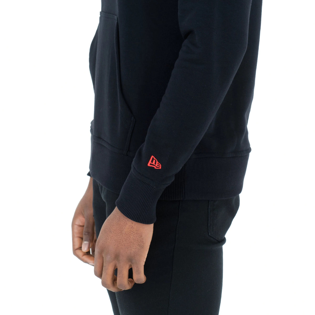 Chicago Bulls NBA Regular Black Pullover Hoodie, side view showing a red embroidered New Era logo on the lower sleeve near the ribbed cuff and a large front pocket on the black fabric.