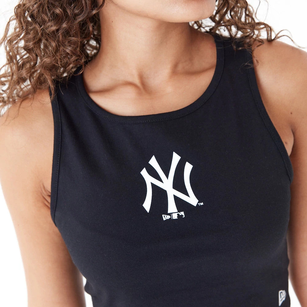 New York Yankees Womens MLB Lifestyle Black Crop Tank Top, front view on a model showing the white NY logo prominently on the chest, with a fitted design and the New Era flag logo on the bottom left hem.