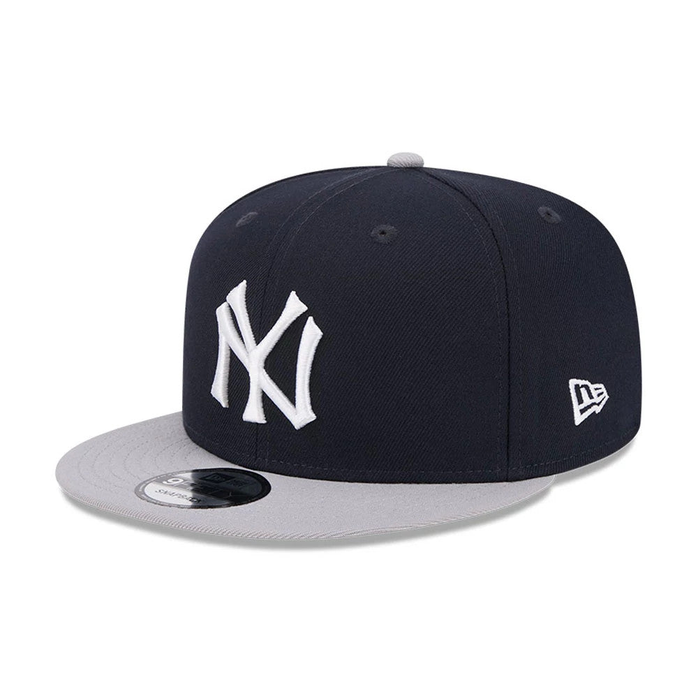 New York Yankees MLB Evergreen Navy New Era 9FIFTY Snapback Adjustable Cap, three-quarter view showing the raised white NY logo on the front panels, grey visor with a 9FIFTY size sticker, and New Era flag logo on the left side.