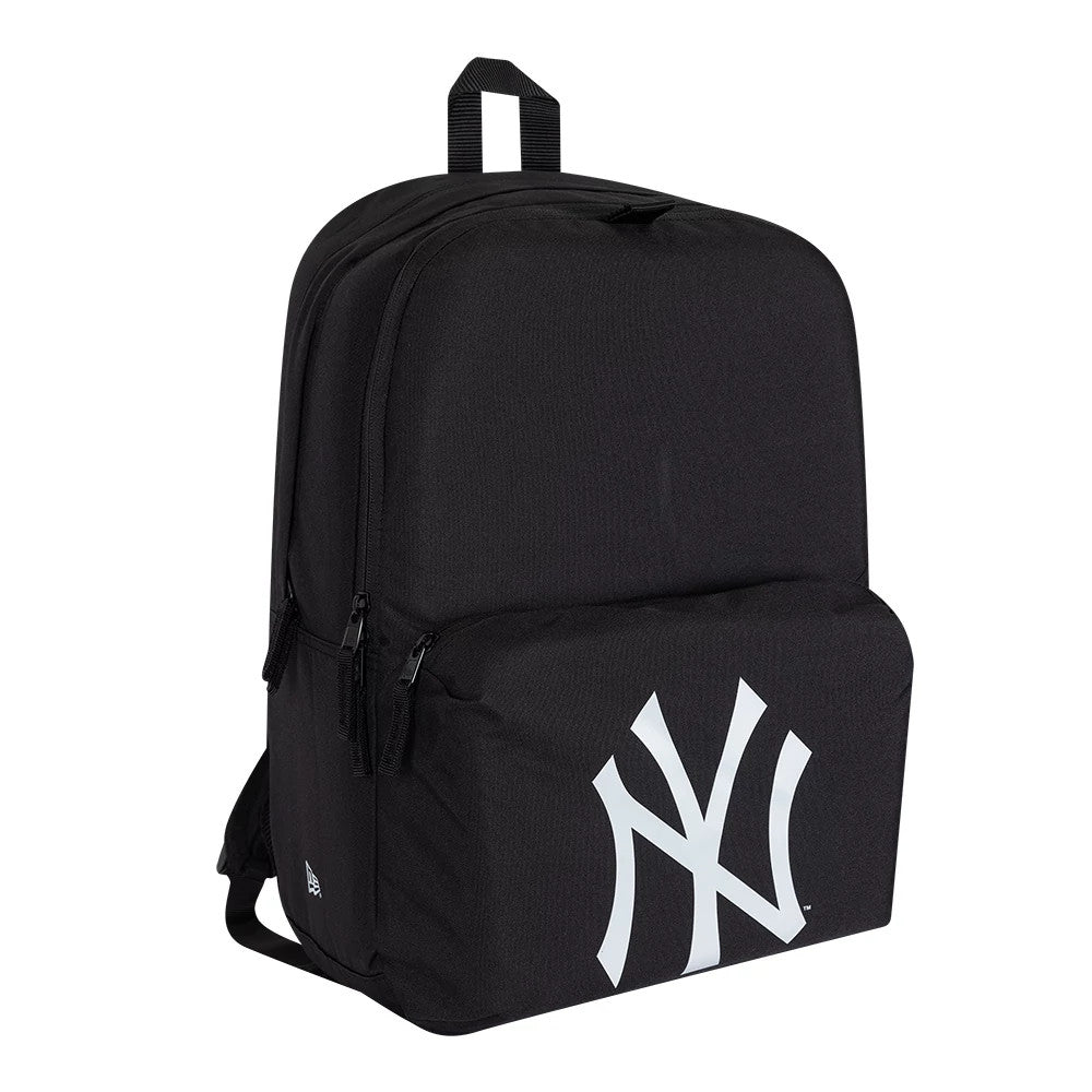 New Era New York Yankees MLB Multi Compartment Black Stadium Backpack, three-quarter view showing a large white Yankees logo prominently embossed on the front pocket, side zips for compartment access, and a fabric carry handle on top.