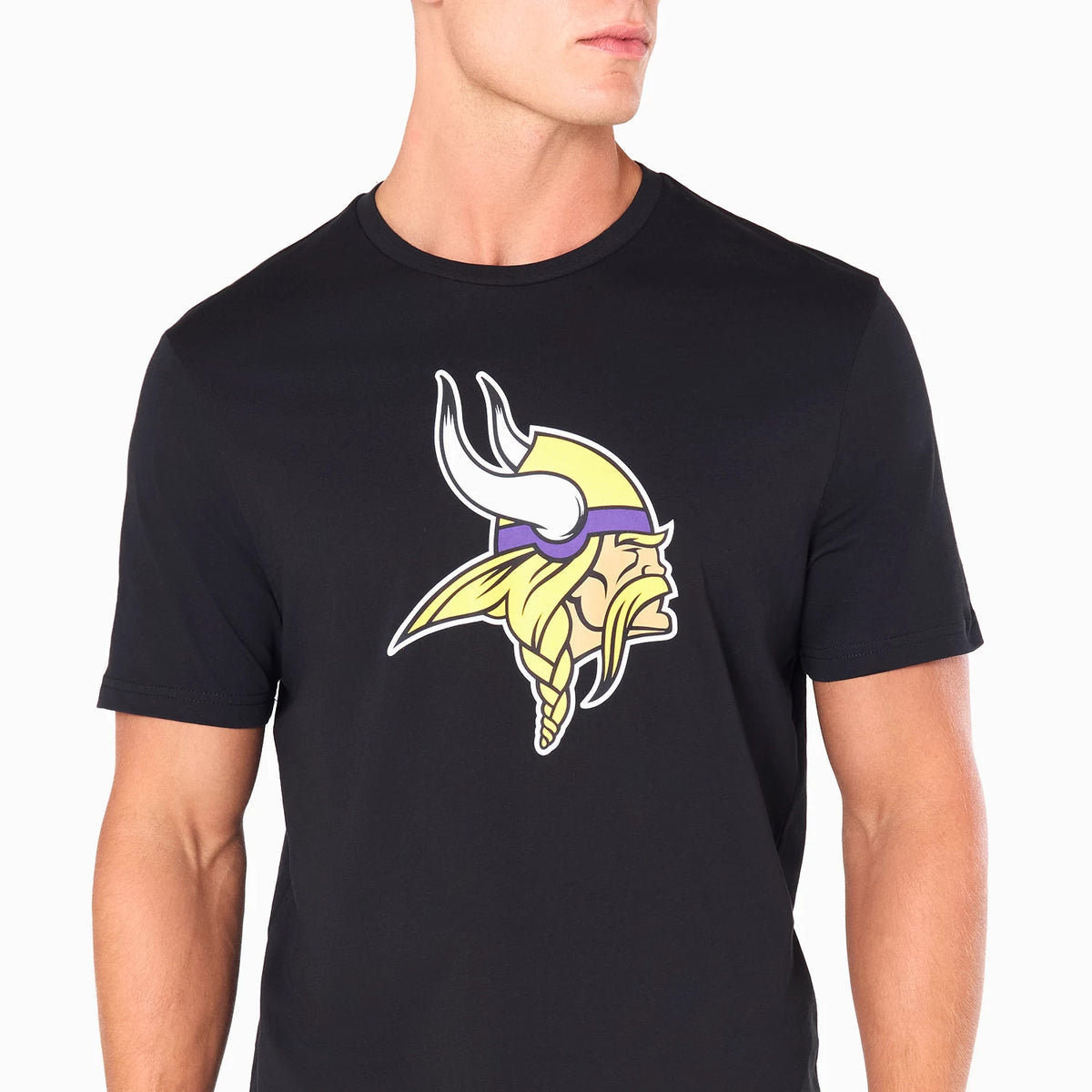 New Era Minnesota Vikings NFL Black T-Shirt, front view showing the prominently centred design of the team's logo, depicting a Viking head in yellow and purple with horns, printed on a plain black short-sleeve shirt worn by a model.