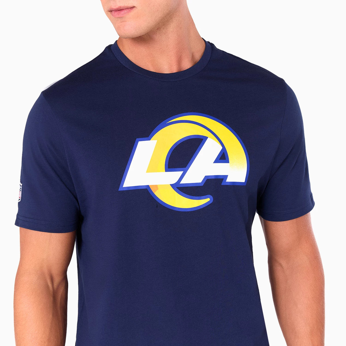 New Era LA Rams NFL Navy T-Shirt, front view showing the large LA Rams logo with a bold yellow and white design on the chest, worn by a model, with a small NFL patch on the left sleeve.