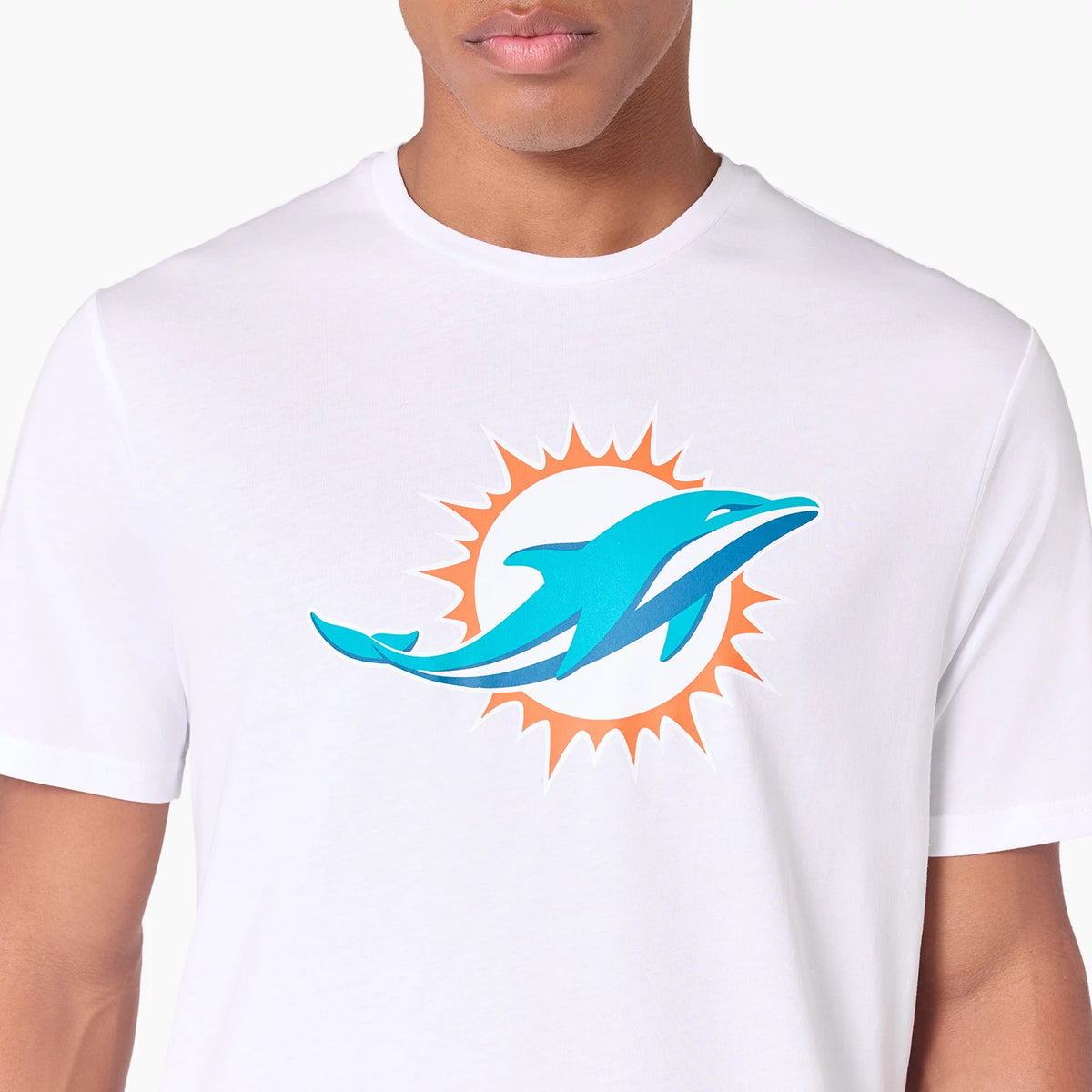 New Era Miami Dolphins NFL White T-Shirt, front view featuring a large teal dolphin graphic with an orange sunburst on the chest, worn by a person with a close-up on the upper torso and shoulders.