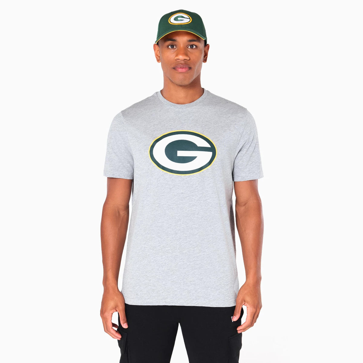 New Era Green Bay Packers NFL Grey T-Shirt, on-model view showing the large printed team logo centred on the chest, the grey short-sleeve design, and a matching green cap featuring the same raised logo worn by the model.
