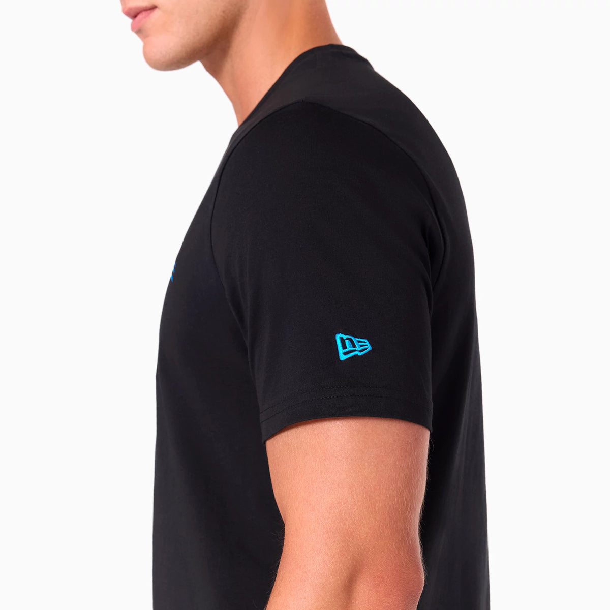 New Era Carolina Panthers NFL Black T-Shirt, side view showing the short sleeve with a raised blue New Era logo on the upper arm and a glimpse of the black fabric's fit on the torso.