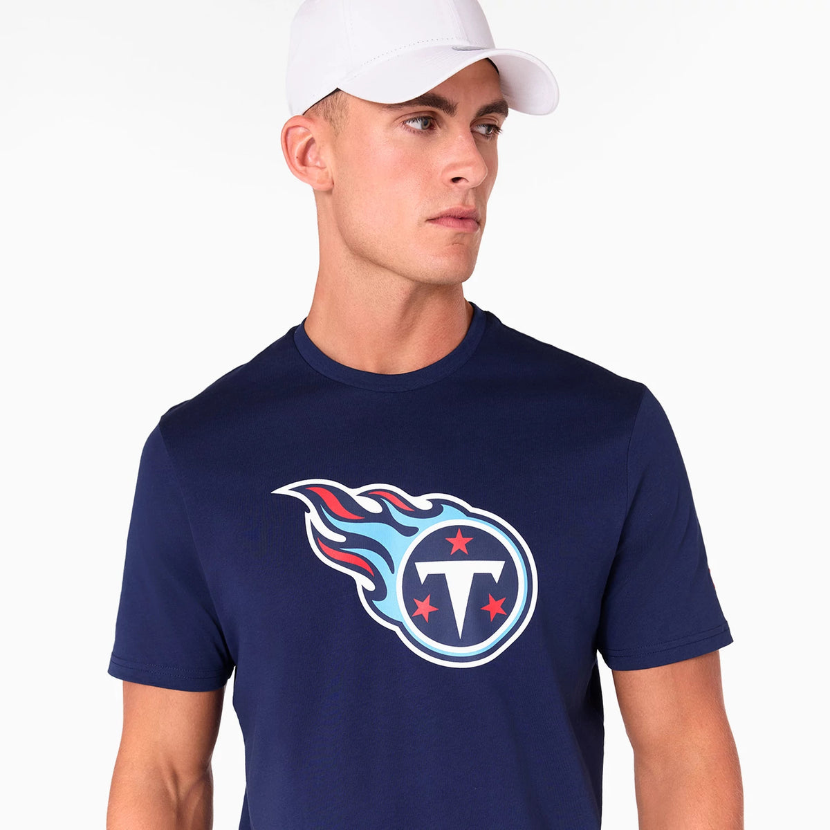 New Era Tennessee Titans NFL Navy T-Shirt, on-model view showing the navy shirt with a large Tennessee Titans logo in white, red, and light blue on the front, paired with a plain white cap.