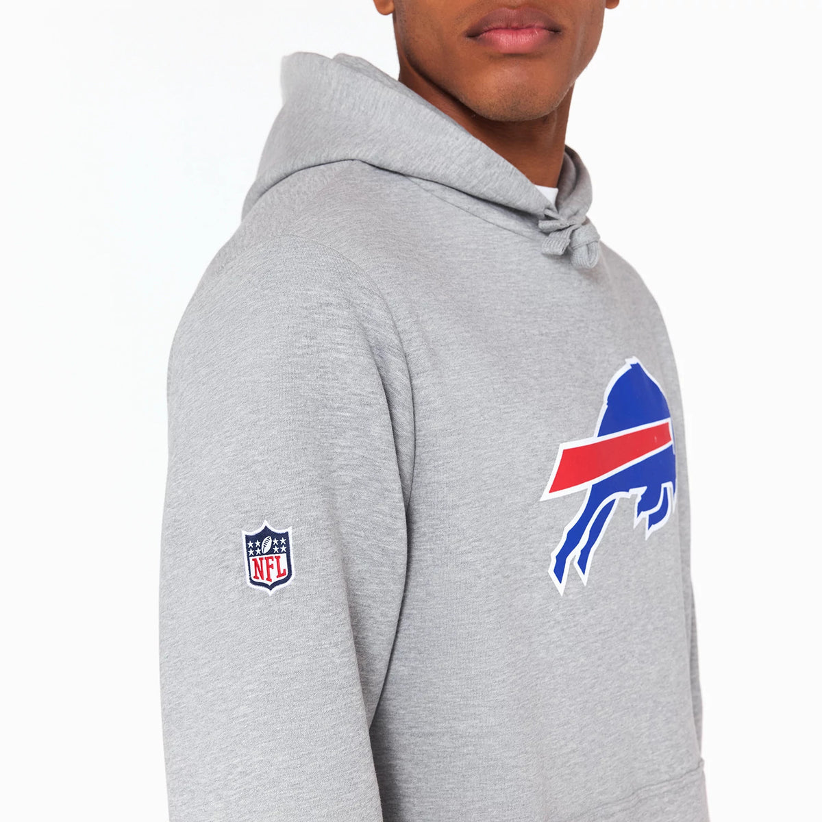 New Era Buffalo Bills NFL Grey Pullover Hoodie, side view showing the grey fabric with a large blue and red Buffalo Bills logo on the chest and a smaller embroidered NFL logo on the sleeve.
