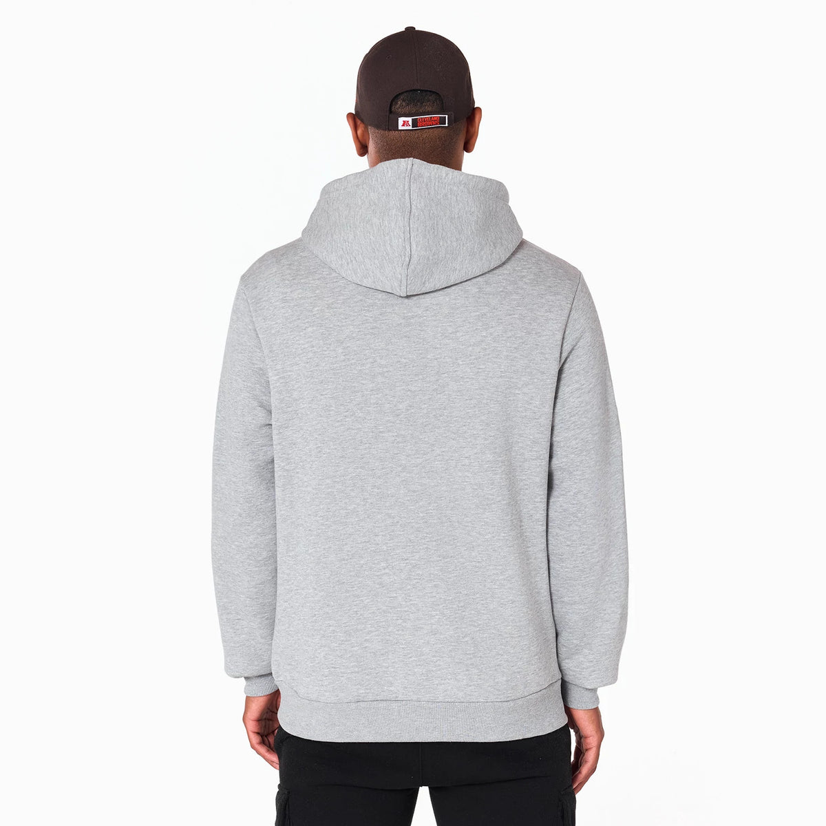 New Era Cleveland Browns NFL Grey Pullover Hoodie, rear view showing the plain grey back with a hood resting low on the shoulders, worn by a model also wearing a brown cap with a debossed logo on the back.