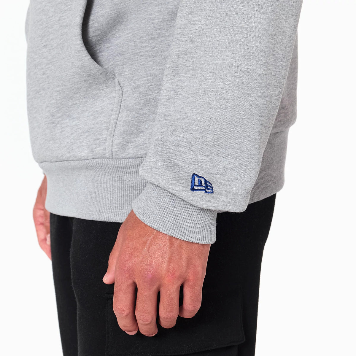New Era Indianapolis Colts NFL Grey Pullover Hoodie, side view showing the ribbed cuff on the grey sleeve, a raised New Era logo in blue above the wrist, and a kangaroo pocket on the front.