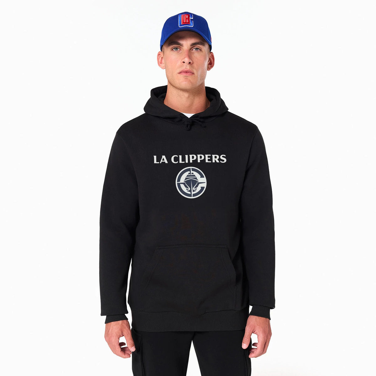 New Era LA Clippers NBA Black Pullover Hoodie, on-model view showing a central raised LA Clippers logo on the chest, the black hoodie with a front pouch pocket and matching drawstrings, worn with a blue cap featuring a raised logo.