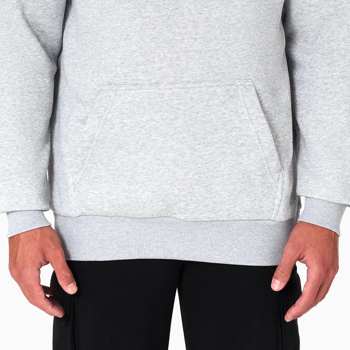 New Era Dallas Mavericks NBA Grey Pullover Hoodie, front view showing the lower half with a kangaroo pocket on the grey fabric, long sleeves with ribbed cuffs and hem, and a plain design.