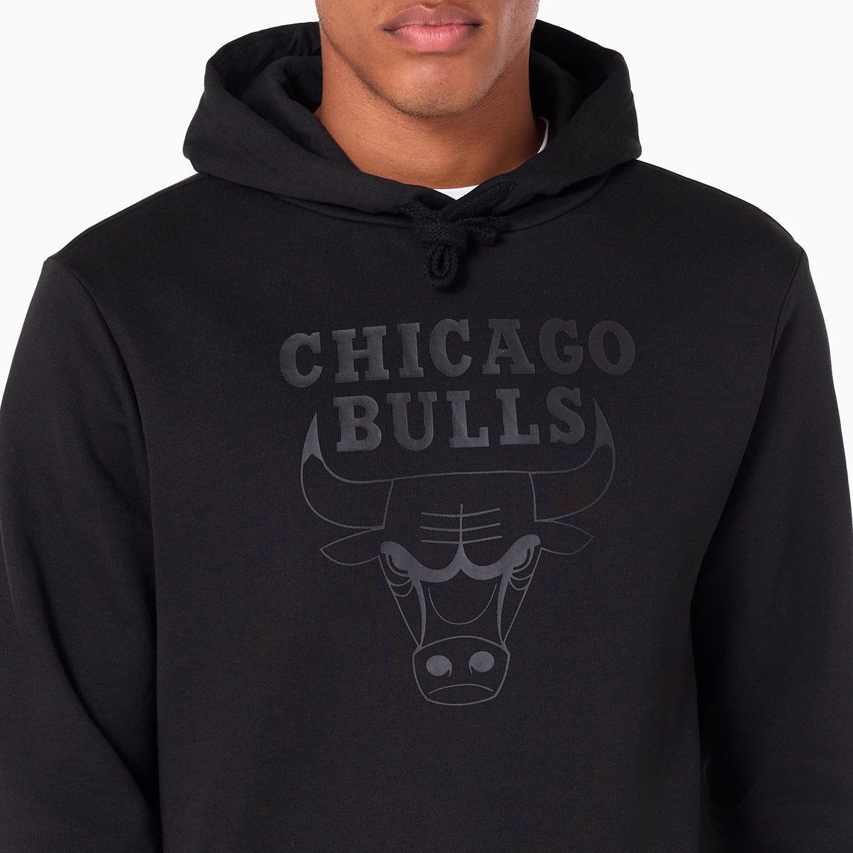 New Era Chicago Bulls NBA Black Pullover Hoodie, front view showing a large raised Chicago Bulls logo on the chest beneath the drawstring hood, with the text in bold letters and stylised bull head design.