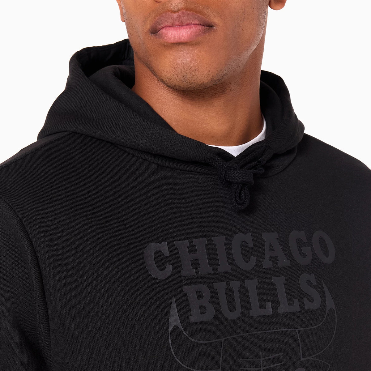 New Era Chicago Bulls NBA Black Pullover Hoodie, three-quarter view showing the black hoodie with a raised Chicago Bulls logo printed across the chest and drawstrings at the neckline.