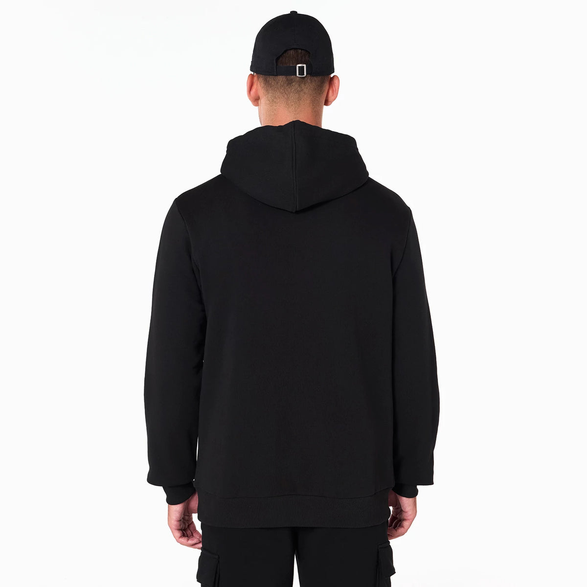 New Era Minnesota Timberwolves NBA Black Pullover Hoodie, rear view showing the plain black back with a hood resting flat, worn by a model also wearing a black cap with a debossed logo on it.