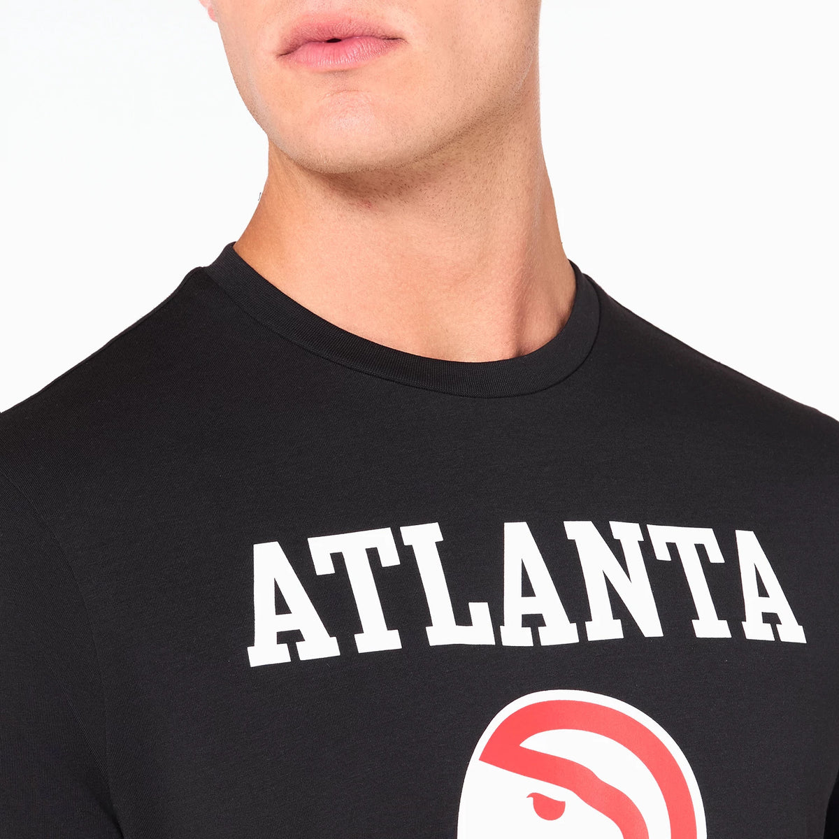 New Era Atlanta Hawks NBA Black T-Shirt, front view showing the black fabric with the word ATLANTA in bold white letters across the chest and a red and white Atlanta Hawks logo positioned below on the upper torso.