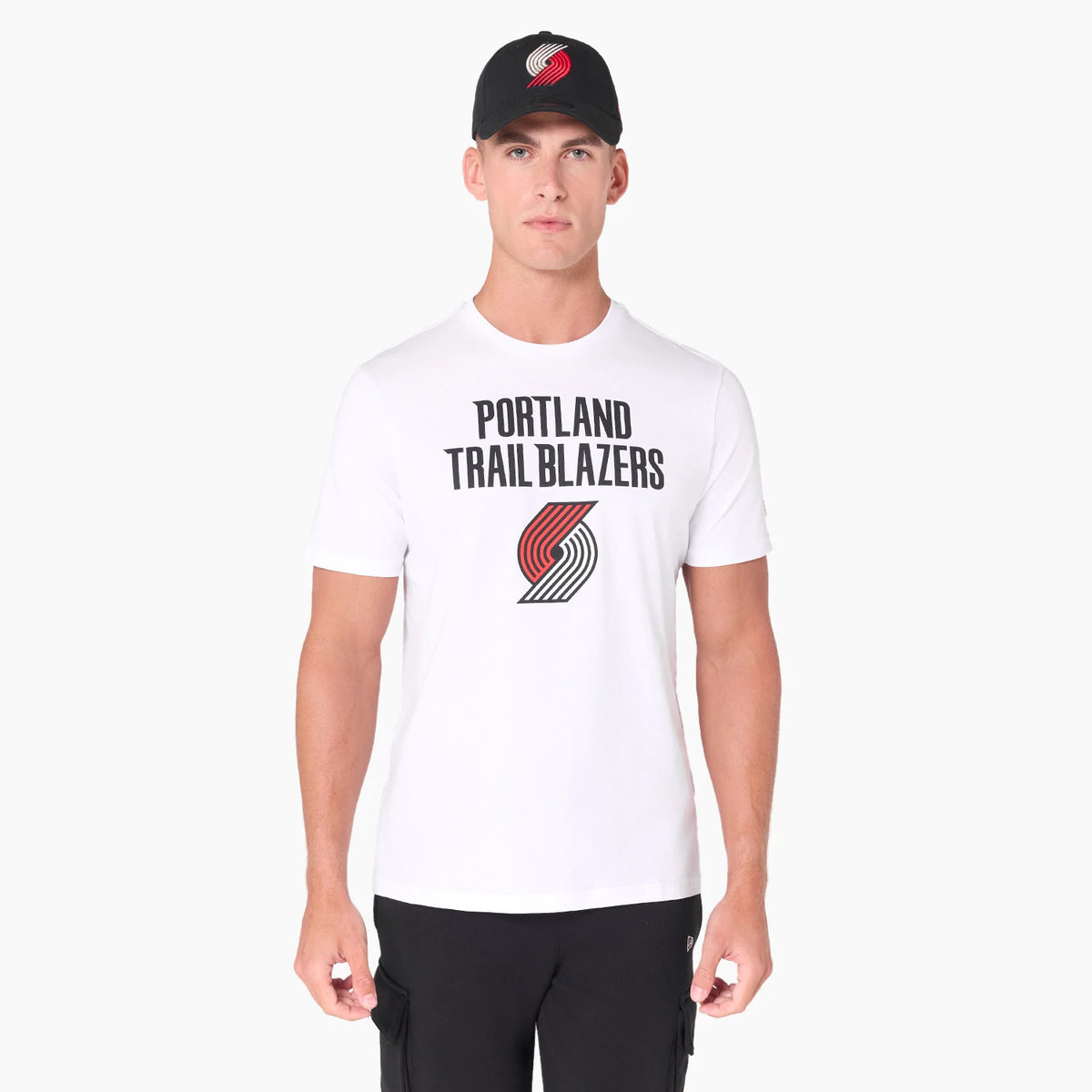 New Era Portland Trail Blazers NBA White T-Shirt, on-model view showing the white T-shirt with large black text and red and black logo on the chest, paired with a black cap featuring a raised red and black logo on the front.