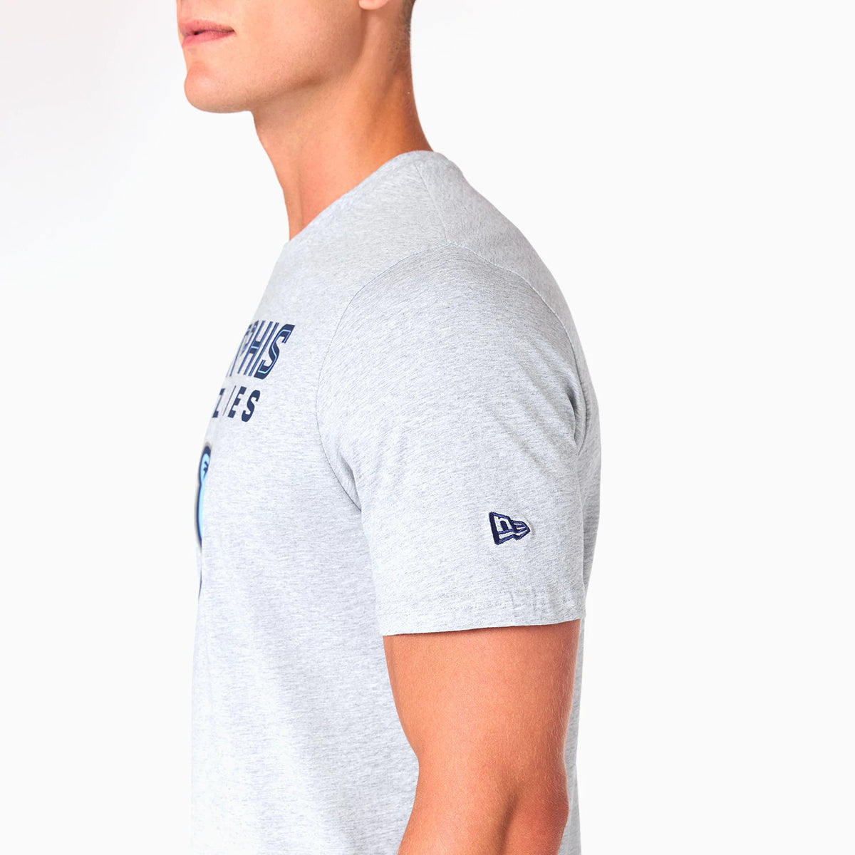 New Era Memphis Grizzlies NBA Grey T-Shirt, side view showing a light grey fabric with Memphis Grizzlies text across the chest and a small embroidered New Era logo in navy on the left sleeve.