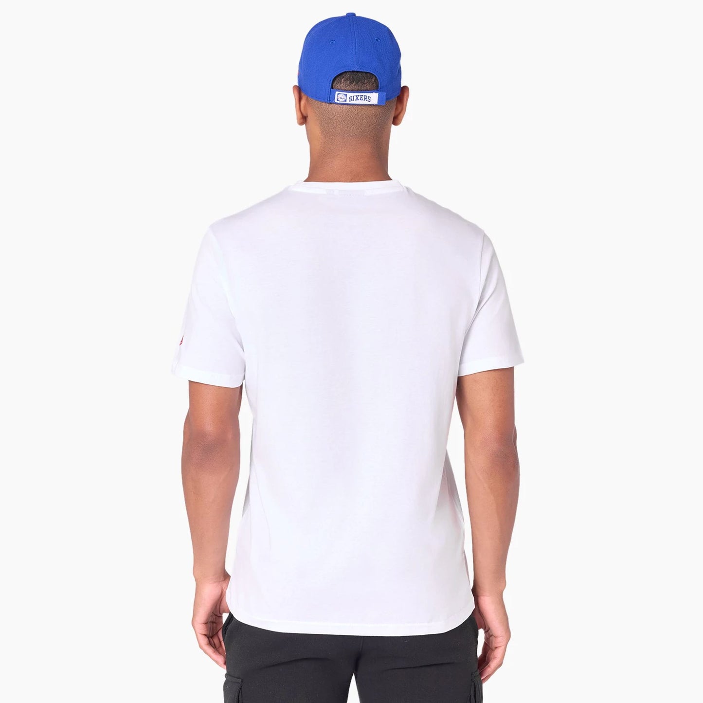 New Era Philadelphia 76ers NBA White T-Shirt, on-model view showing a plain back of the white shirt with short sleeves, paired with a blue cap that has a raised rectangular logo at the back.