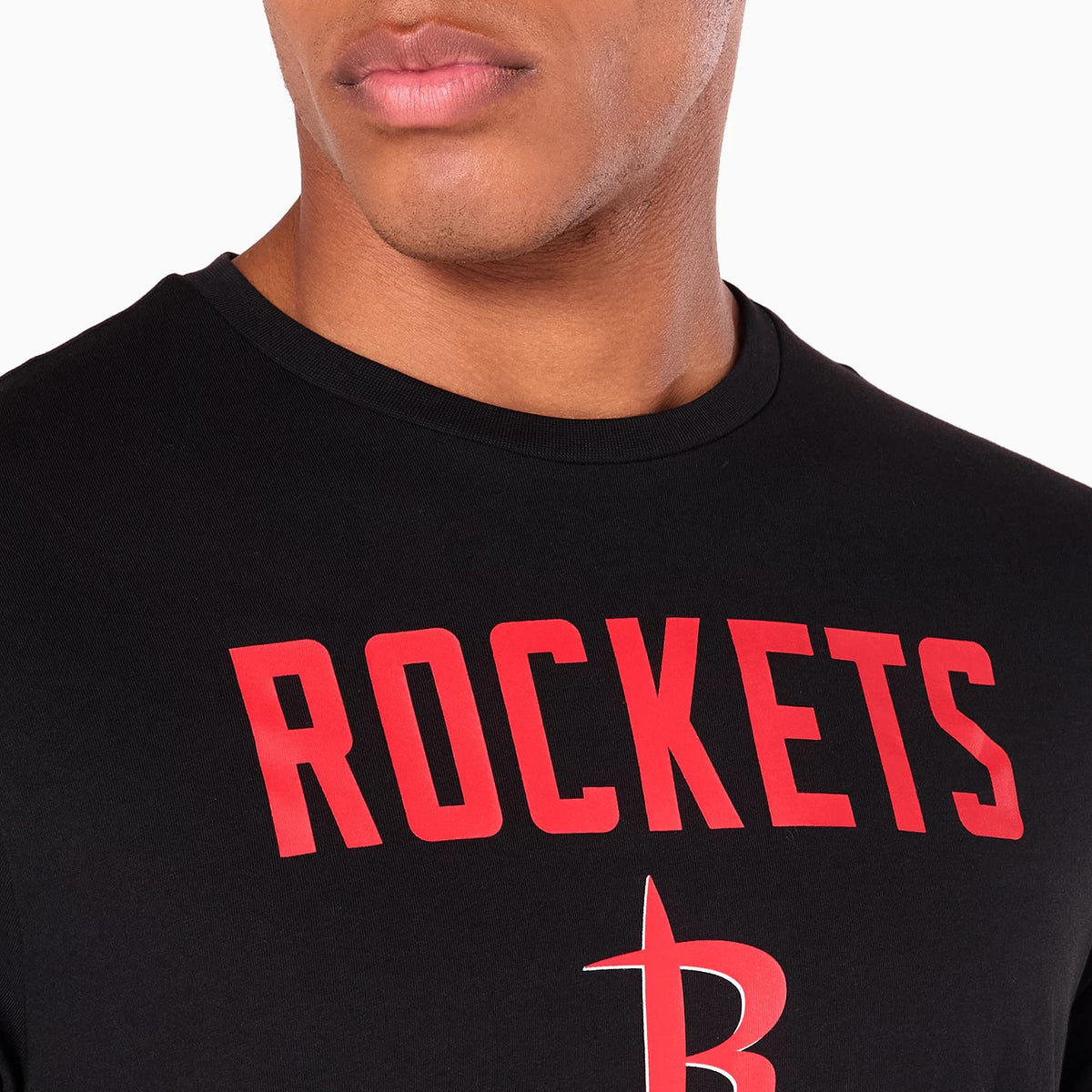 New Era Houston Rockets NBA Black T-Shirt, on-model view showing the black T-shirt with bold red ROCKETS text across the chest and a red stylised R logo beneath, against a plain background.