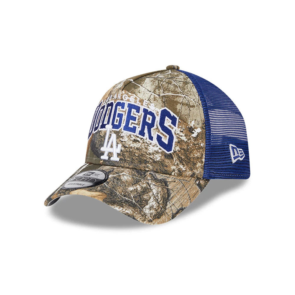 LA Dodgers MLB Realtree Camo Dark Blue New Era 9FORTY A-Frame Trucker Adjustable Cap, three-quarter view showing raised blue Dodgers lettering, white LA logo on the front panel, and New Era flag logo on the mesh blue left side.