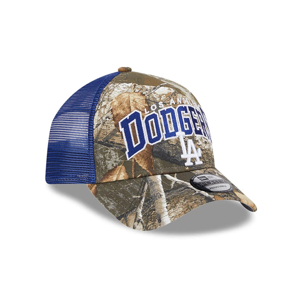 LA Dodgers MLB Realtree Camo Dark Blue New Era 9FORTY A-Frame Trucker Adjustable Cap, front view showing the raised blue and white embroidered Dodgers logo on the camo front panel, blue mesh back panels and the black 9FORTY size sticker on the visor.